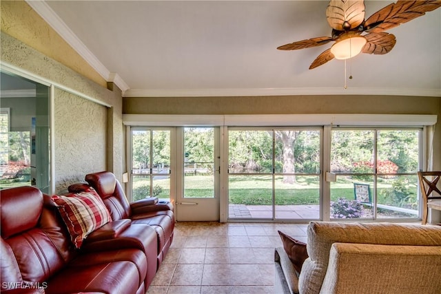 living room with ceiling fan, light tile patterned flooring, crown molding, and vaulted ceiling