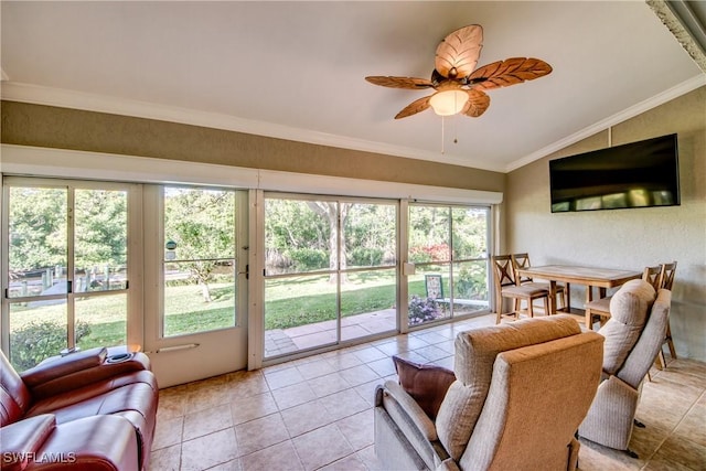 living room with crown molding, ceiling fan, lofted ceiling, and light tile patterned flooring