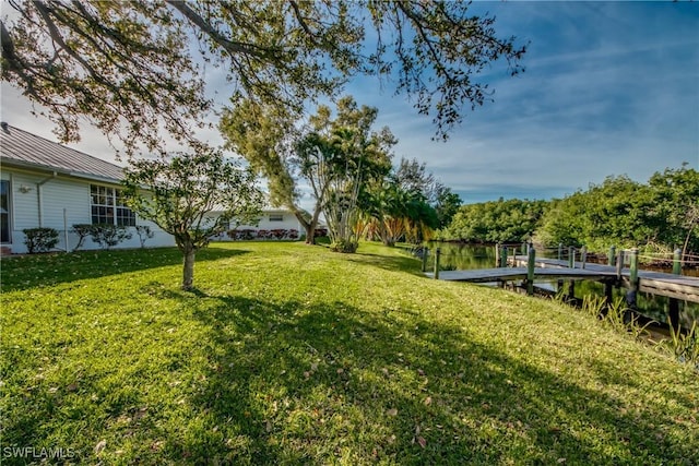 view of yard featuring a water view and a dock