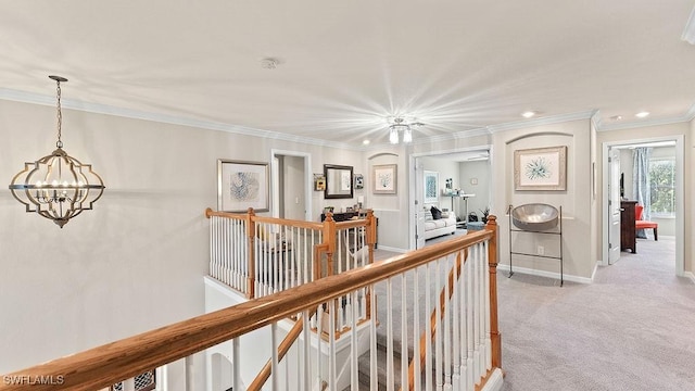 hall with light colored carpet, an inviting chandelier, and crown molding