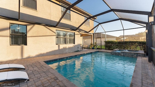 view of swimming pool featuring a patio area, a lanai, and an in ground hot tub