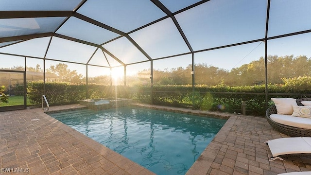 view of pool with glass enclosure and a patio area