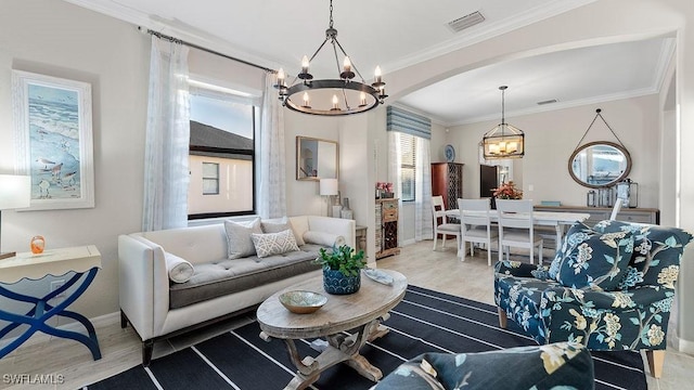 living room with a chandelier, ornamental molding, and hardwood / wood-style flooring