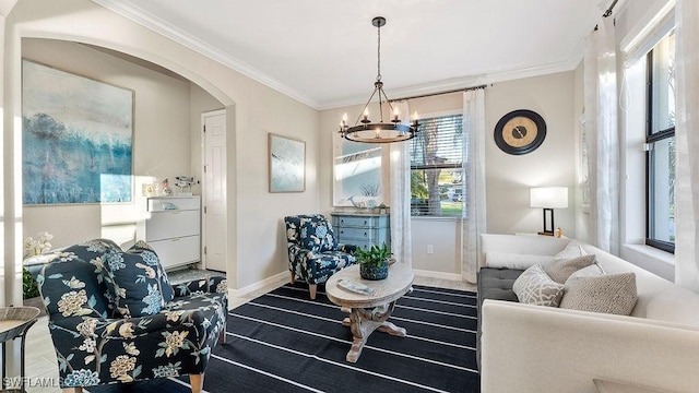 living room featuring plenty of natural light, crown molding, and an inviting chandelier