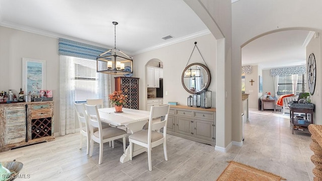 dining space featuring ornamental molding and an inviting chandelier