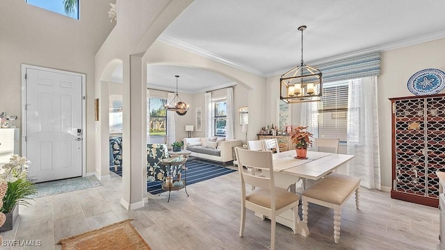 dining space featuring plenty of natural light, crown molding, and a notable chandelier