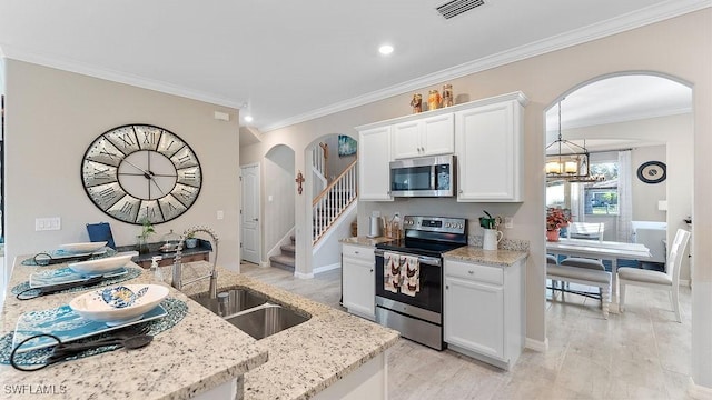 kitchen featuring light stone counters, ornamental molding, stainless steel appliances, sink, and white cabinets