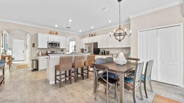 dining area with crown molding and a chandelier