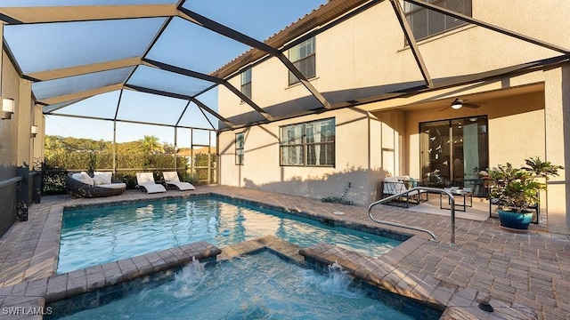 view of swimming pool featuring a pool with connected hot tub, glass enclosure, and a patio area