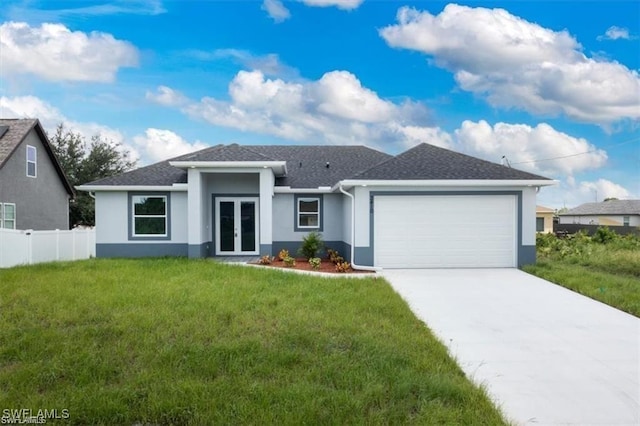 view of front facade with a front yard, french doors, and a garage