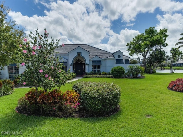 view of front facade with a water view and a front lawn