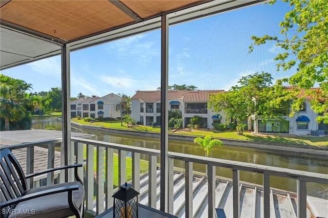 sunroom / solarium featuring a water view