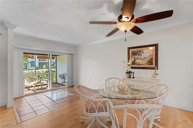 dining room with a textured ceiling, ceiling fan, ornamental molding, and light tile patterned flooring