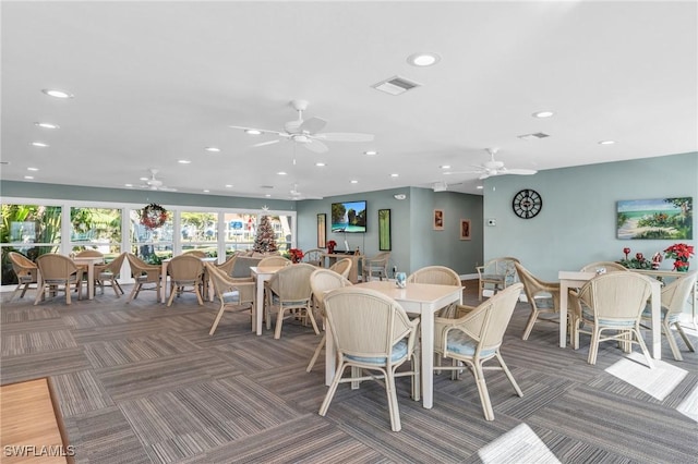 dining area with ceiling fan and dark carpet