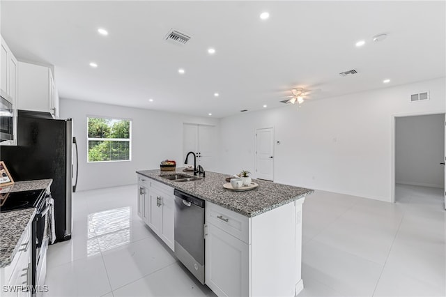 kitchen featuring sink, white cabinets, stainless steel appliances, and a center island with sink