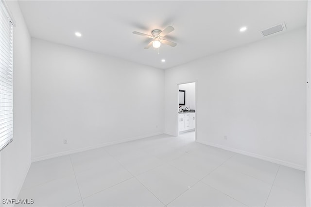 empty room featuring ceiling fan and light tile patterned flooring