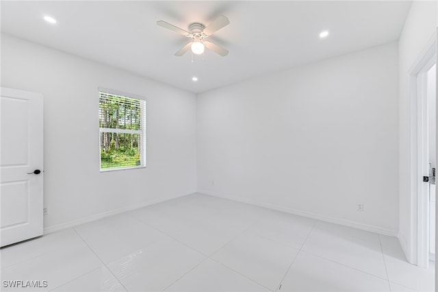 tiled spare room with ceiling fan