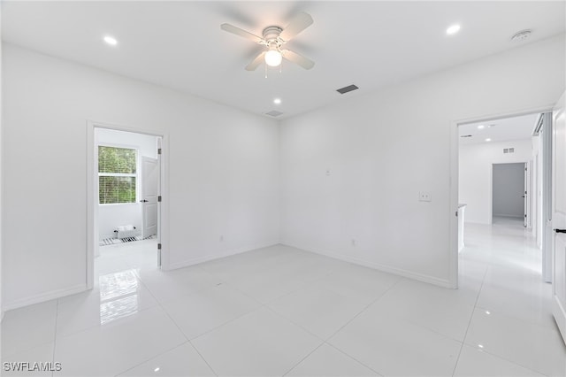 tiled spare room with ceiling fan