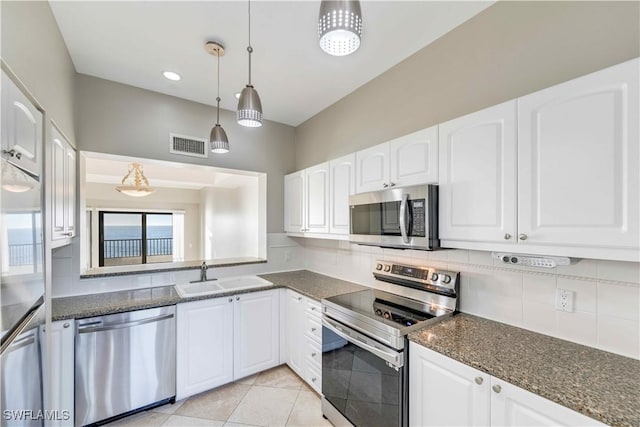 kitchen with sink, white cabinets, decorative light fixtures, and appliances with stainless steel finishes