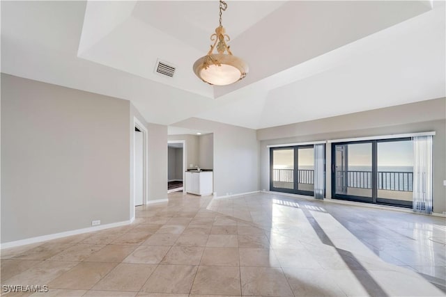 empty room with a tray ceiling and a healthy amount of sunlight