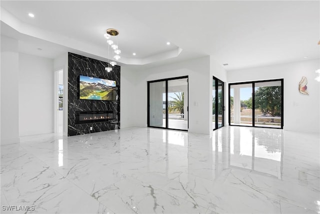 unfurnished living room with a tray ceiling and a premium fireplace