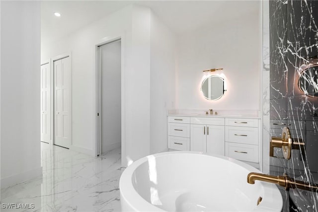 bathroom with a tub to relax in and vanity