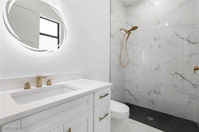 bathroom featuring vanity, toilet, and a tile shower