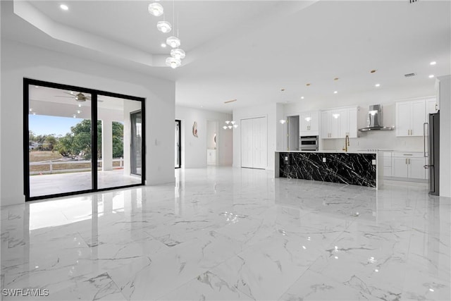 unfurnished room featuring a raised ceiling and ceiling fan