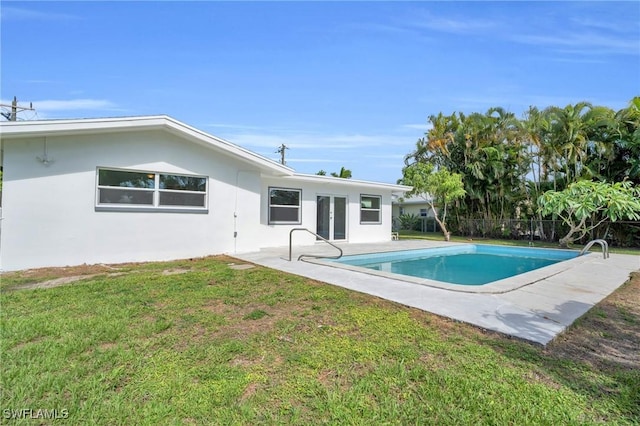 view of pool featuring a yard, french doors, a patio area, and a fenced in pool