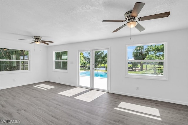 spare room featuring french doors, dark wood-type flooring, and baseboards