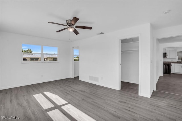 unfurnished bedroom featuring wood finished floors, visible vents, and baseboards