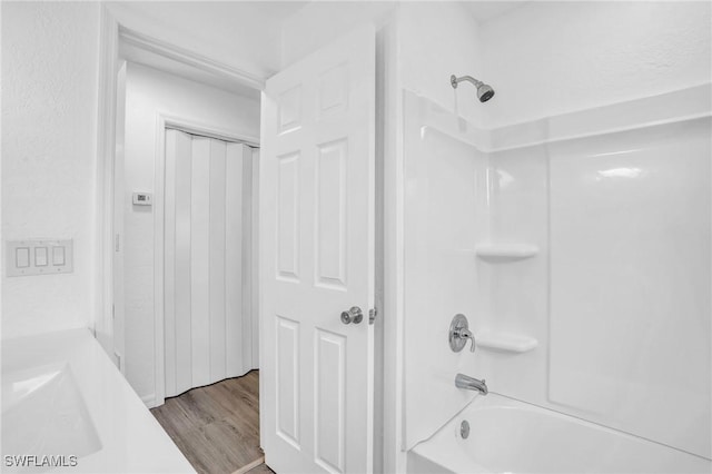 full bath featuring shower / bath combination and wood finished floors