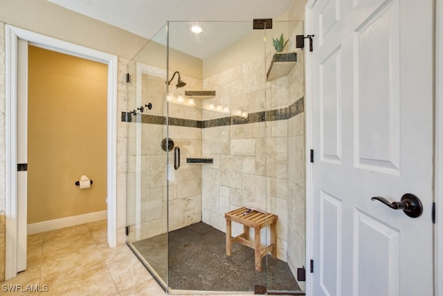 bathroom with tile patterned flooring and a tile shower