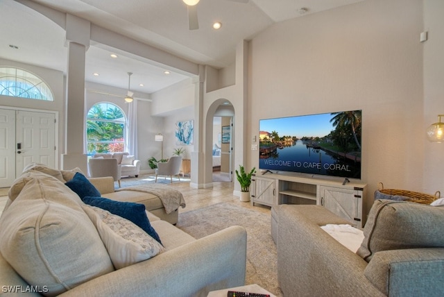 living room featuring ceiling fan and a high ceiling