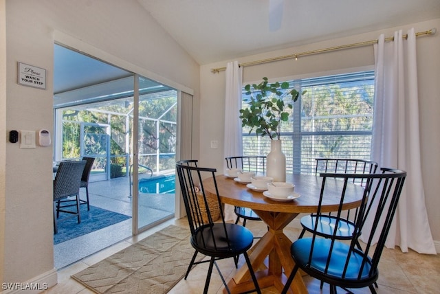 dining room with lofted ceiling and light tile patterned floors