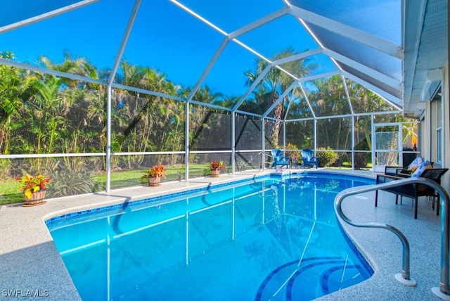 view of swimming pool featuring glass enclosure and a patio area