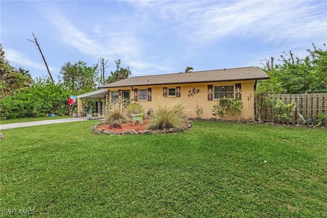 rear view of property featuring a lawn and a carport