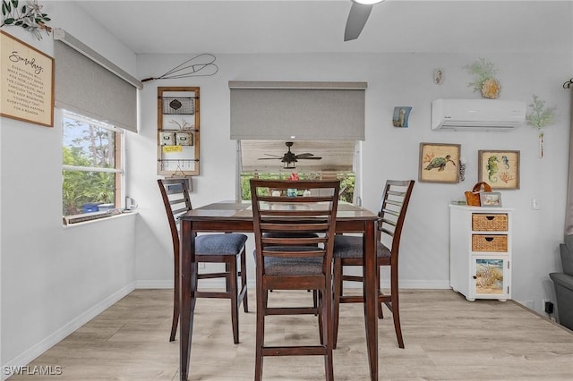 dining space featuring a wall unit AC, ceiling fan, and light hardwood / wood-style flooring