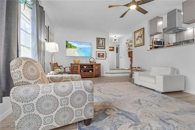 living room featuring ceiling fan and light hardwood / wood-style floors