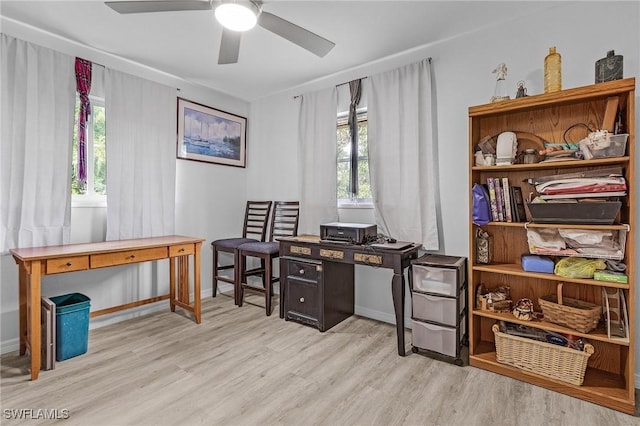 office area with light wood-type flooring, ceiling fan, and a wealth of natural light