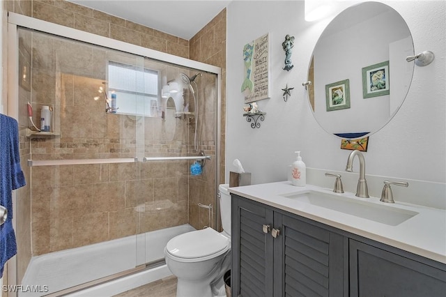 bathroom with walk in shower, vanity, and toilet