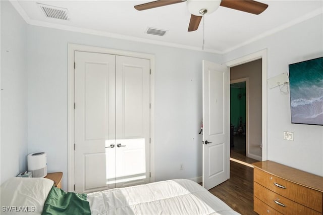 bedroom featuring ceiling fan, dark hardwood / wood-style flooring, crown molding, and a closet