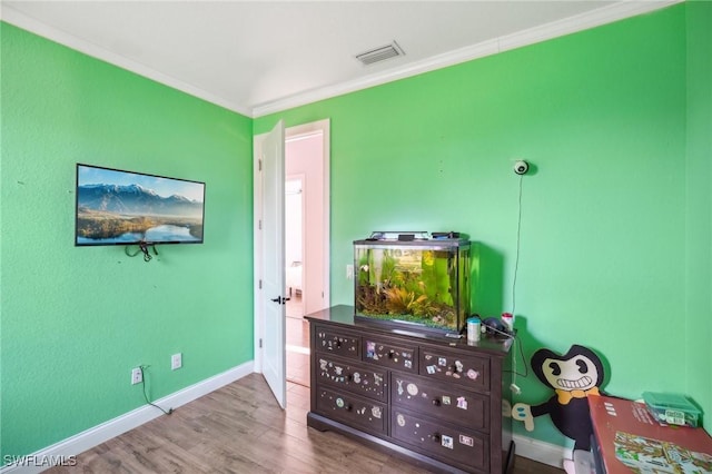 bedroom featuring hardwood / wood-style flooring and ornamental molding