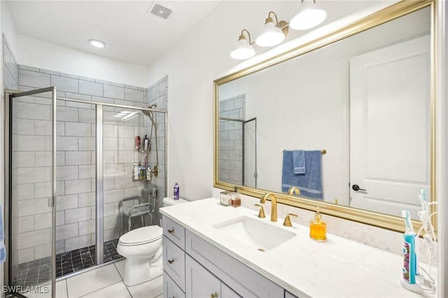 bathroom with tile patterned flooring, vanity, toilet, and a shower with shower door