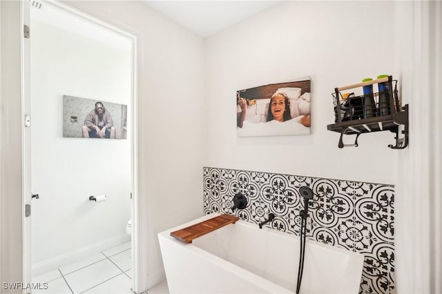 bathroom with tile patterned flooring, toilet, and a washtub