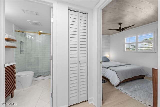 bedroom with ceiling fan, light hardwood / wood-style floors, and connected bathroom