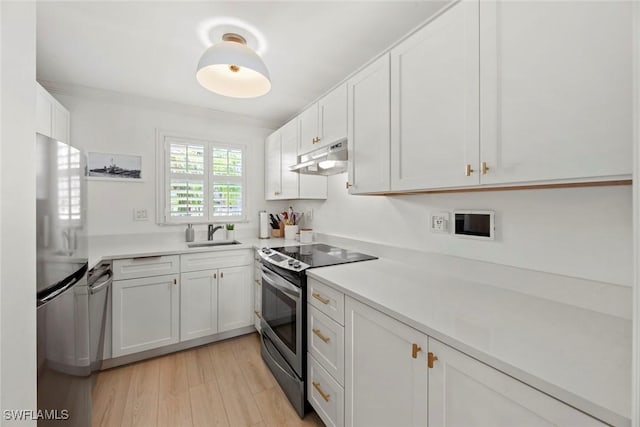 kitchen with appliances with stainless steel finishes, sink, and white cabinetry