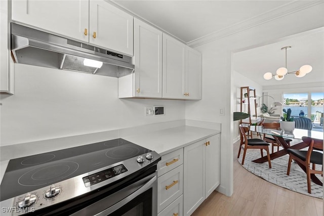 kitchen with light wood-type flooring, pendant lighting, white cabinets, and electric stove