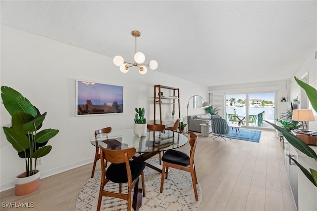 dining space featuring light hardwood / wood-style flooring and a chandelier