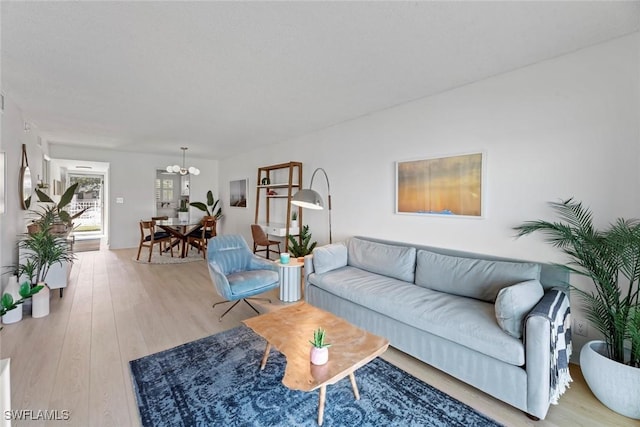 living room featuring an inviting chandelier and light wood-type flooring